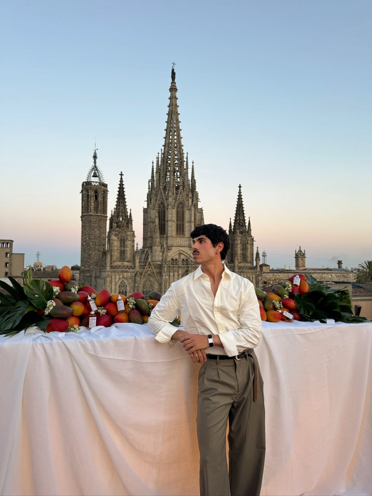 Composición de fruta tropical para Maison Margiela frente a una catedral al atardecer