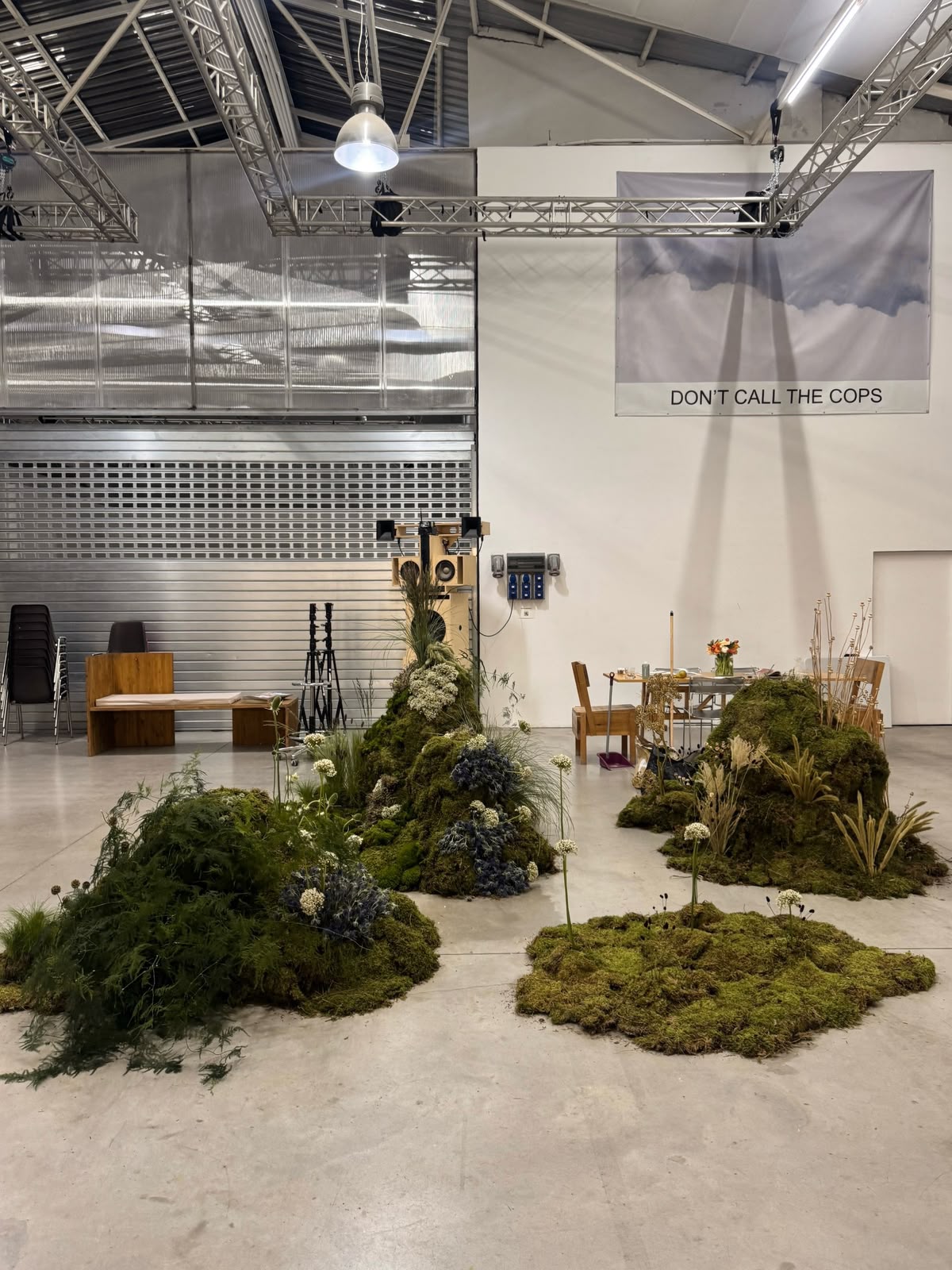 Composición botánica de musgo, flores y vegetación para Satorisan en un espacio industrial