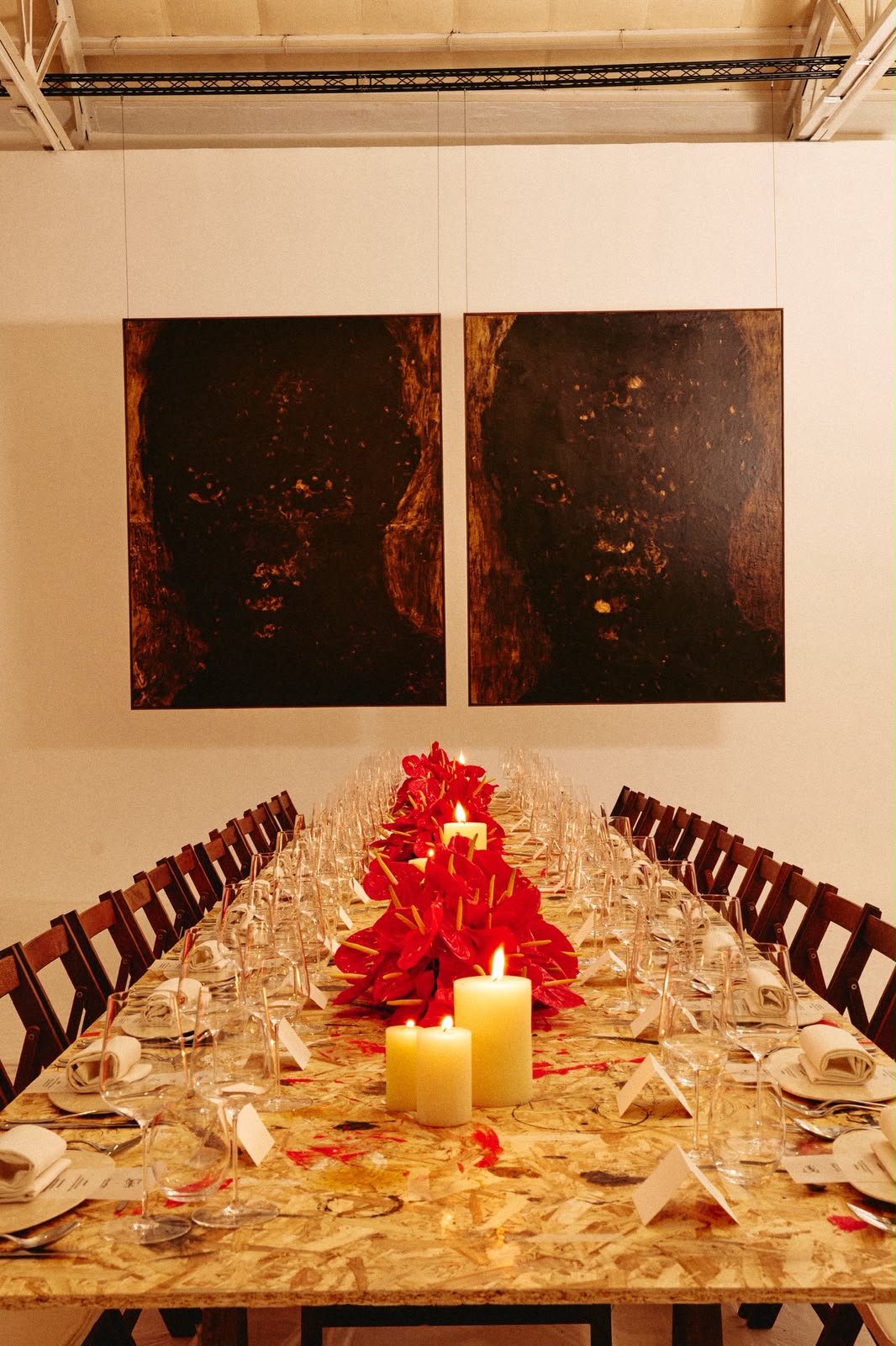 Mesa preparada con anturios rojos y velas para una cena de Christian Louboutin