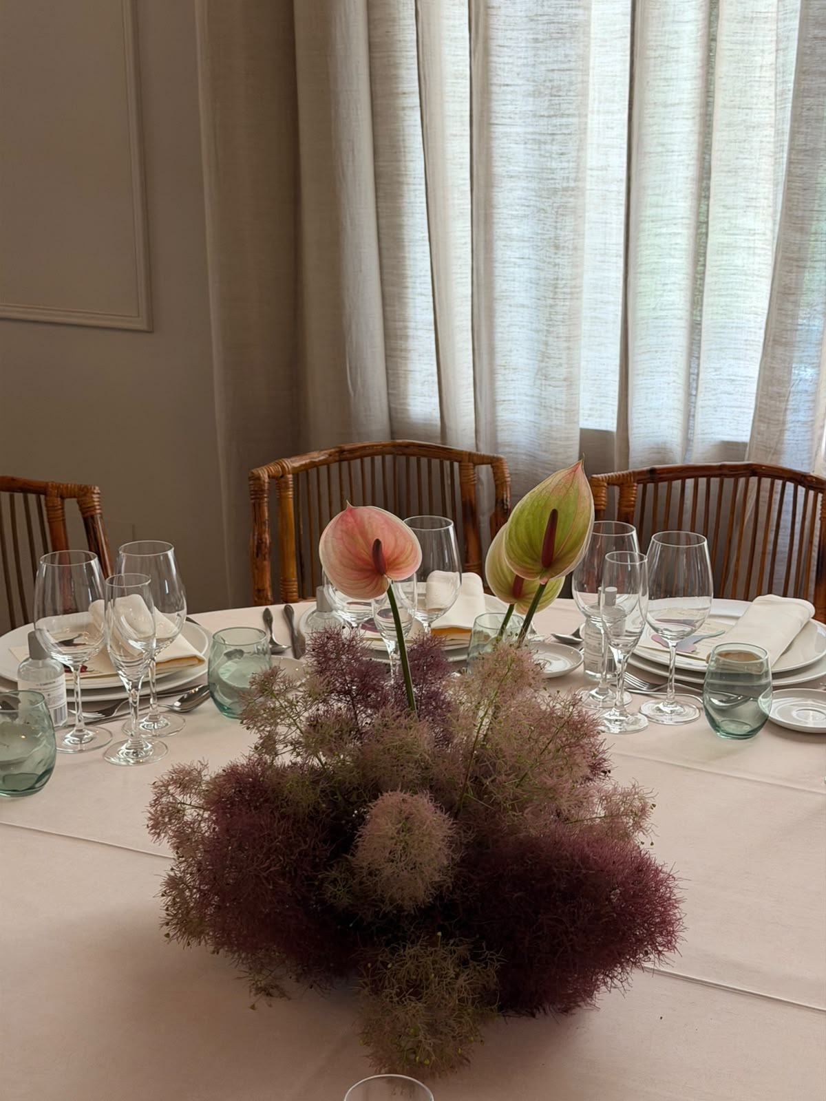 Centro de mesa de boda con anturios y flores en tonos rosa y burdeos