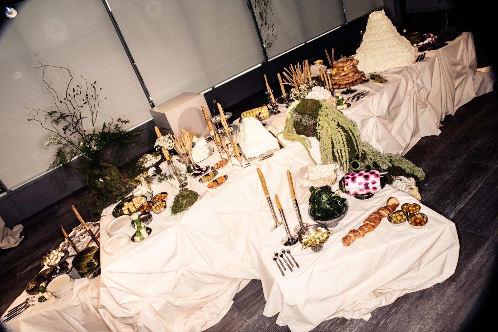 Mesa escultórica con flores, musgo y una presentación de H&M Studio