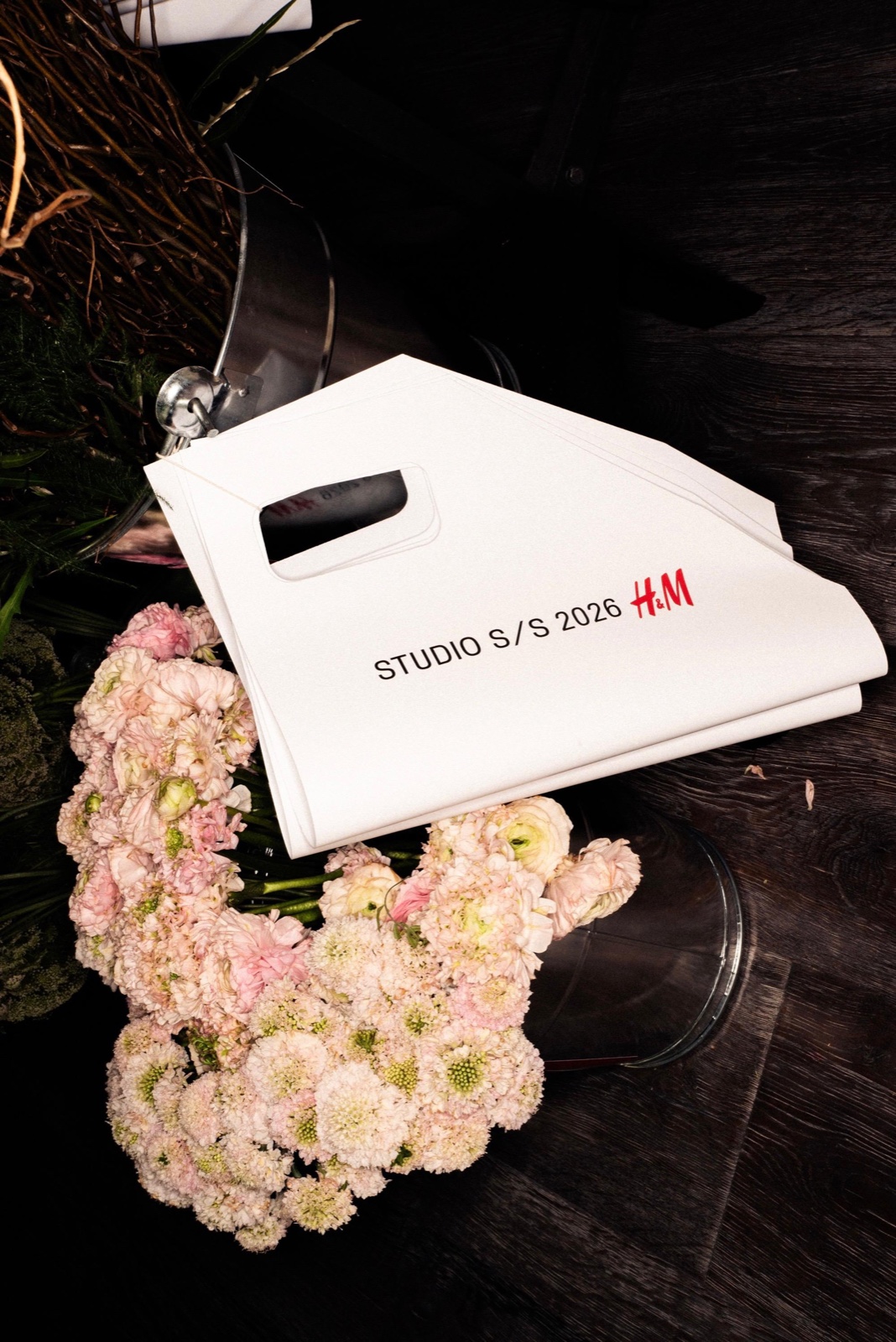 Detalle floral rosa junto a una invitación de H&M Studio